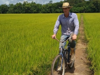 homem andando de bicicleta em lavoura